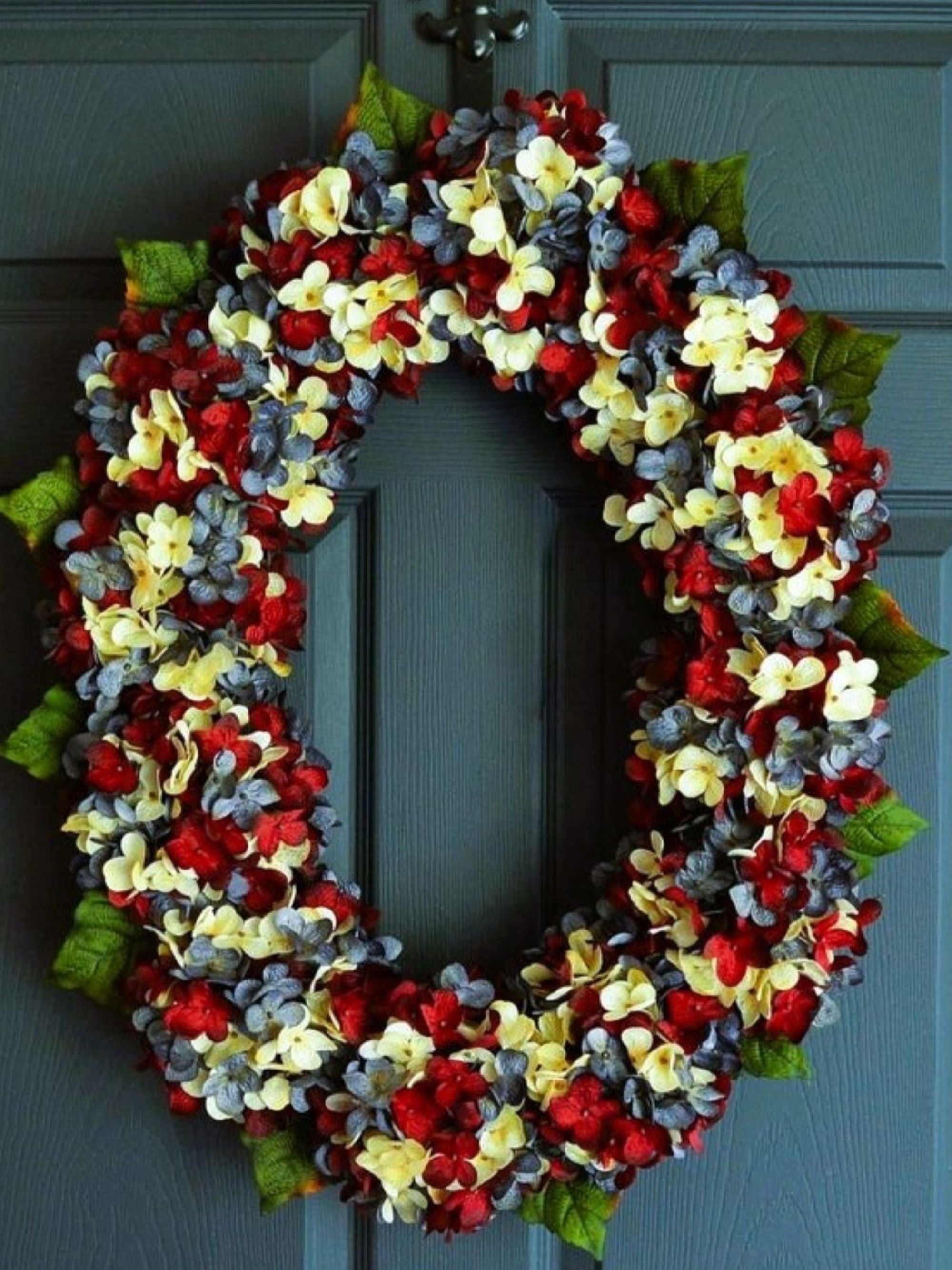Americana oval front door wreath with red white and blue hydrangeas on natural grapevine base