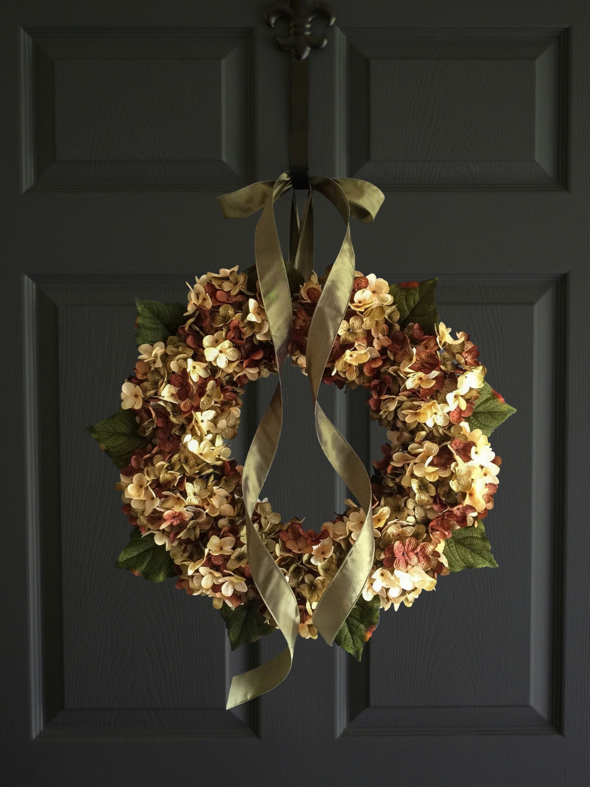 Autumn farmhouse porch decorated with brown green cream hydrangea wreath