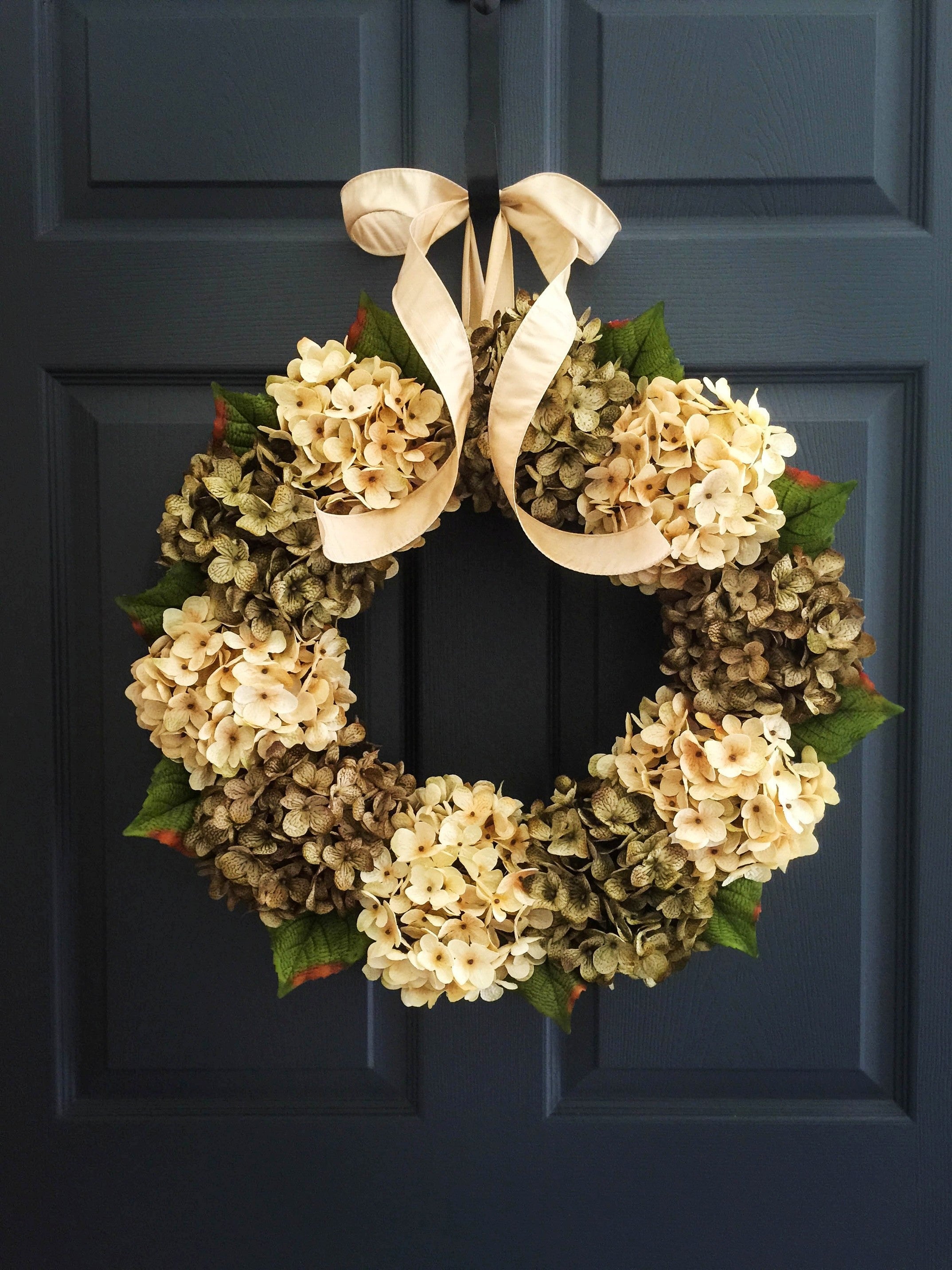 Green hydrangea front door wreath hanging on farmhouse style entryway